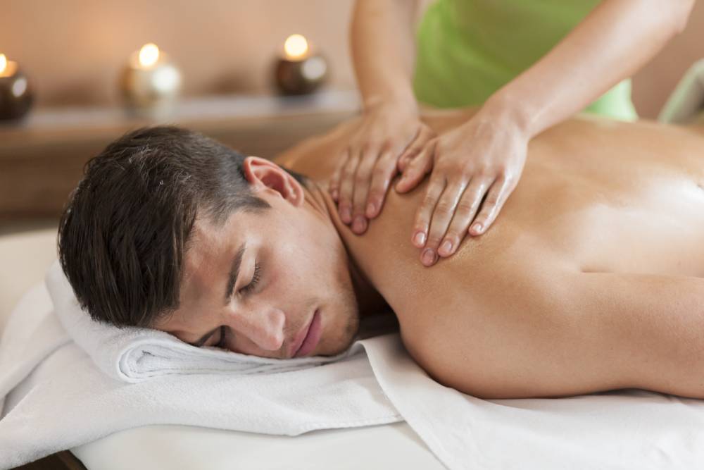 Asian massage therapist performing deep tissue therapy in Venice spa
