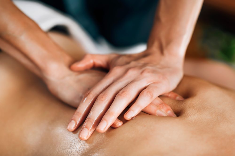 Massage therapist performing deep tissue work on client's back
